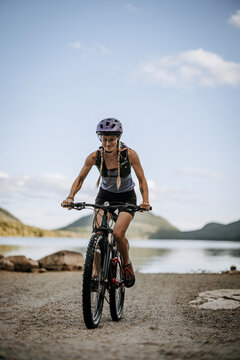 Smiling female cyclist next to lake in Acadia National Park,
