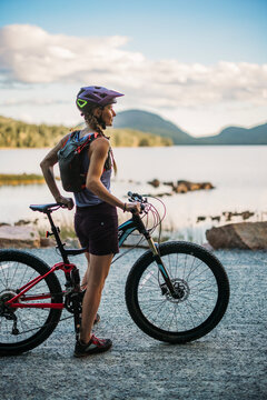 Woman mountain biker next to Eagle Lake, Acadia National Park.