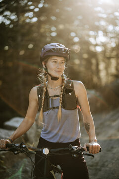 Female mountain biker with helmet poses for portrait.