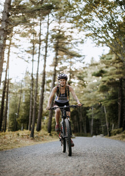 Mountain biker cycles along dirt carriage road, Acadia National Park.
