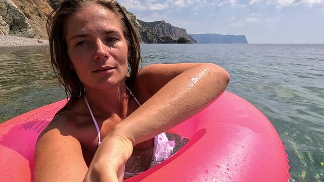 Woman, Beach, Float - Woman in pink float taking selfie at the beach on sunny summer day.