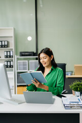 Young attractive Asian female office worker business suits smiling in office .