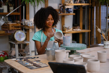 Young women is making earthenware at workshop.