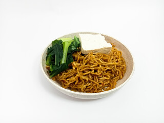 Spicy fried noodles with tofu and vegetables, beautifully plated in a wheat bowl without chopsticks and fork, isolated on white. A hearty meal for spice lovers.