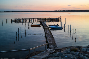 Obraz premium Boats resting peacefully in a small harbor near Gothenburg during a vibrant sunset