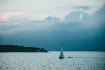 Serene seascape with sailboat under cloudy sky