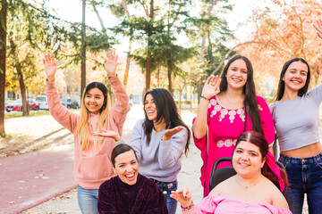 Young women with cerebral palsy celebrating with friends in park