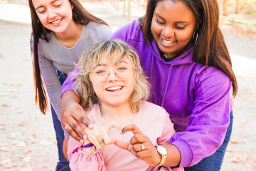 Women with cerebral palsy making heart shape with hands, embracing diversity and inclusion