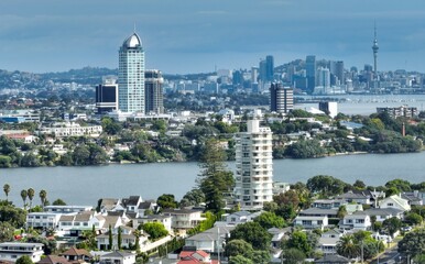 Auckland, New Zealand cityscape, featuring a mix of high-rise buildings, residential homes, and a...