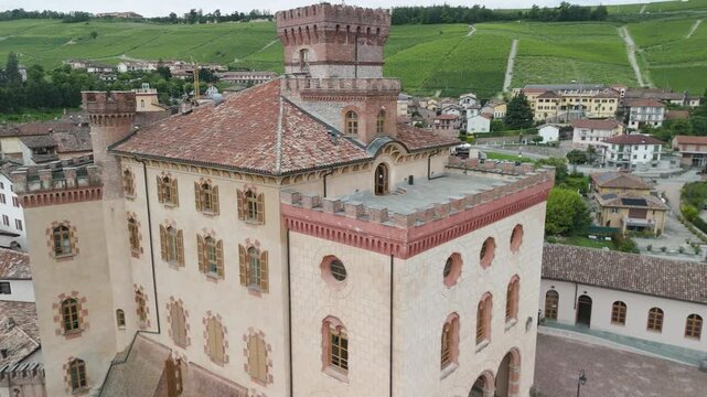 Barolo Castle in Langhe Wine Region, Cuneo, Piedmont, Italy. 4K Aerial view of the village and the vineyards. Circling to the left, close to the castle.