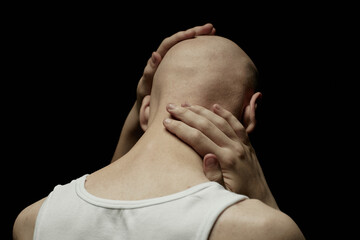 Rear view of pale bald man touching skin of neck and head in feeling of deep regret or anxiety...
