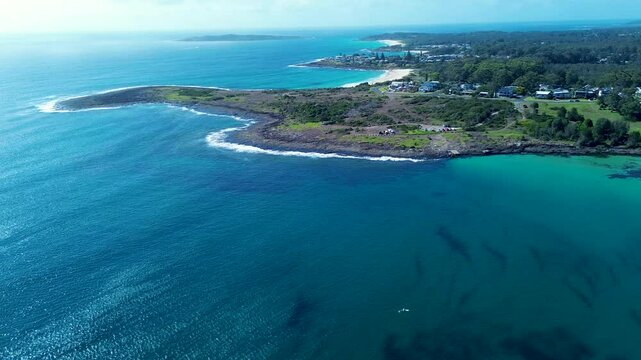Drone aerial landscape of Bawley Point town coastline headland with sandy beach rocky bay residential homes suburban town Shoalhaven Australia travel holidays tourism