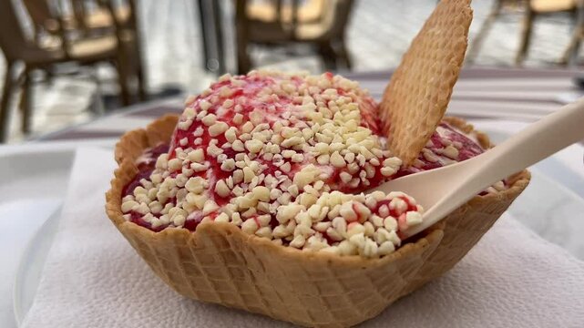 Eating spaghetti ice cream with strawberry sauce and white chocolate close up