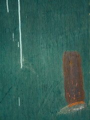 Vertical abstract view of green metal doors with hints of white and rust