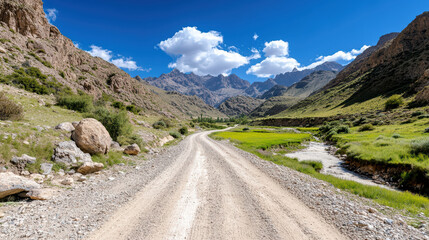 Naklejka premium scenic dirt road winding through stunning mountain landscapes and lush greenery