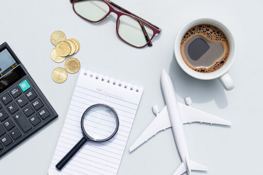 A creative setup featuring an airplane miniature placed beside a note, symbolizing travel preparation and holiday planning ideas.