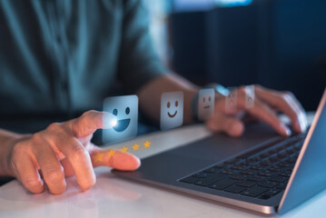 Close-up of a hand selecting a happy face and five stars on a digital feedback interface,...