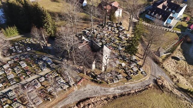 Aerial View of an Old Church in the Middle of a Cemetery in a Rural Landscape, zoom out, 