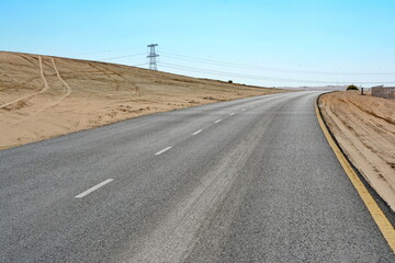 Winding black asphalt road through the sand dunes of  United Arab Emirates. An asphalt road...