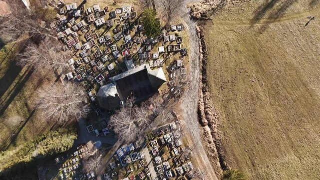 Aerial View of an Old Church in the Middle of a Cemetery in a Rural Landscape, zoom out, rotate, top