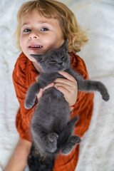 Child playing with kittens at home. Selective focus.