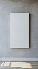 A blank white canvas mounted on a textured gray wall with sunlight streaming onto the wooden floor, creating a minimalistic atmosphere.