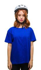 Young beautiful woman wearing cyclist helmet over isolated background with serious expression on face. Simple and natural looking at the camera.