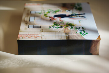 a closed photo book with wedding photos on a white table