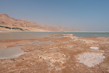 Scenic view of the Dead Sea with salt formations and mountains in the background