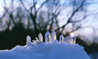 set of clear quartz minerals on snow, winter nature background. Gemstones for esoteric Crystal...