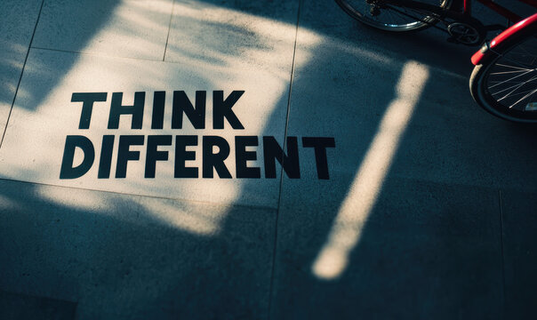 Naklejki Inspirational Think Different Text with Shadow Play on Modern Pavement