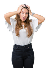 Obraz premium Young beautiful brunette business woman over isolated background Crazy and scared with hands on head, afraid and surprised of shock with open mouth