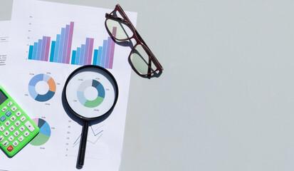 Business Graph Paper Viewed Under Magnifying Glass as Financial Concept