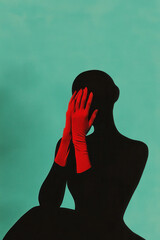 Silhouette with Red Gloves Against Teal Background: A Modern Artistic Expression