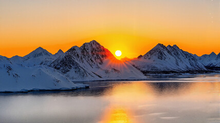Sunrise over snowy mountains reflecting on calm water