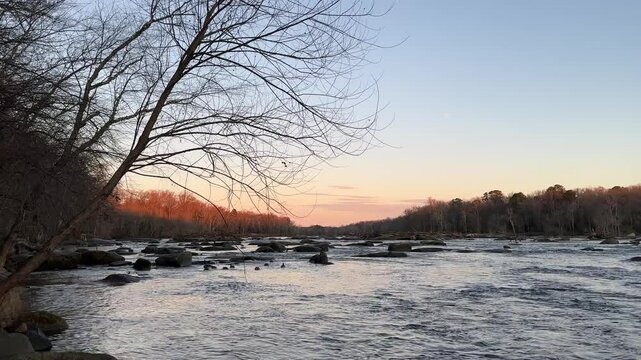 Wide shot of the sun rising over the James River during winter at Pony Pasture, Richmond VA