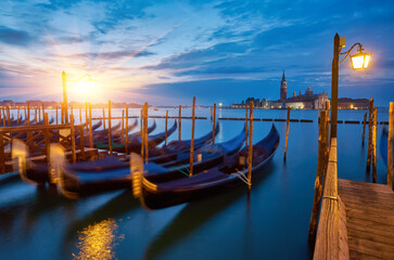 The most popular and romantic place in Venice. Gondolas moored at St. Mark's Square with the Church of San Giorgio di Maggiore in the background at sunset dawn, Venice. © Ryzhkov Oleksandr