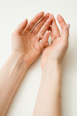The woman's hands seem to be holding something. Ready to help or accept. Gesture isolated on white background. A helping hand is stretched out to save. Decorated with a French manicure.
