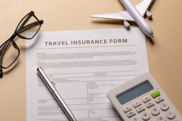 Travel insurance form neatly placed on a beige wooden surface with a blurred backdrop.