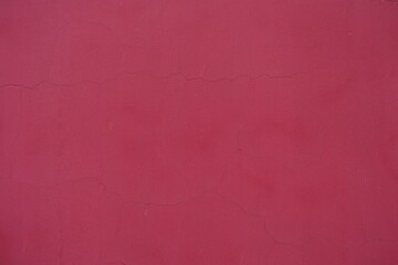 Surface of old and cracked raspberry red painted wall