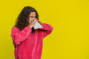Unhealthy teenager girl sneezes wipe snot into napkin coughing with seasonal flu symptoms covering...