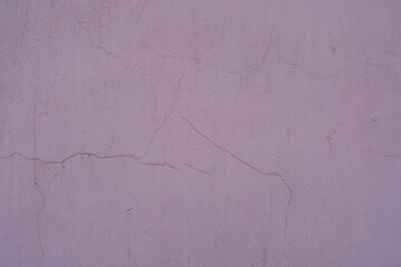 Close view of dusty and cracked pale pink painted wall