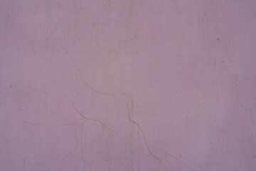 Surface of dusty and cracked pale pink painted wall