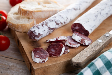 Fuet.Dry cured fuet sausage on wooden table