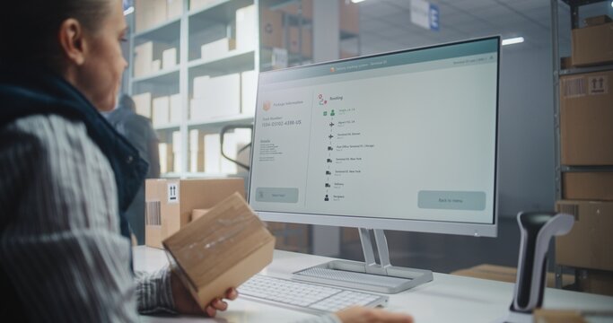 Female Inventory Manager Scans Code on Cardboard Box with Barcode Scanner, Checks Parcel Information. Computer Screen Shows Delivery Tracking System for Monitoring Package with Online Orders. Close Up - Powered by Adobe