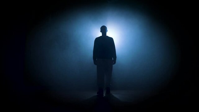 silhouette of a man posing in dark space with bright backlight. High quality 4k footage