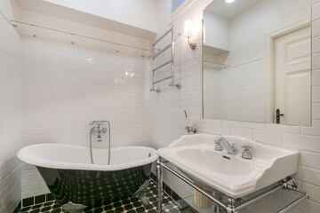 Bathroom design in classic English style. Antique bathtub, on curved legs. Stylish .accessories.