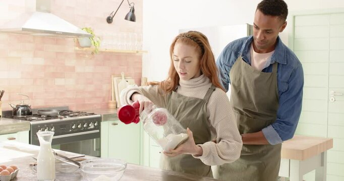Diverse couple baking together in cozy kitchen, preparing holiday treats
