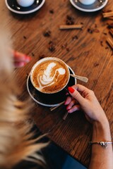 Woman holding cappuccino with latte art.