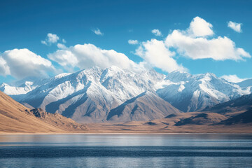 A serene mountain landscape with snow-capped peaks and a calm lake under a blue sky.